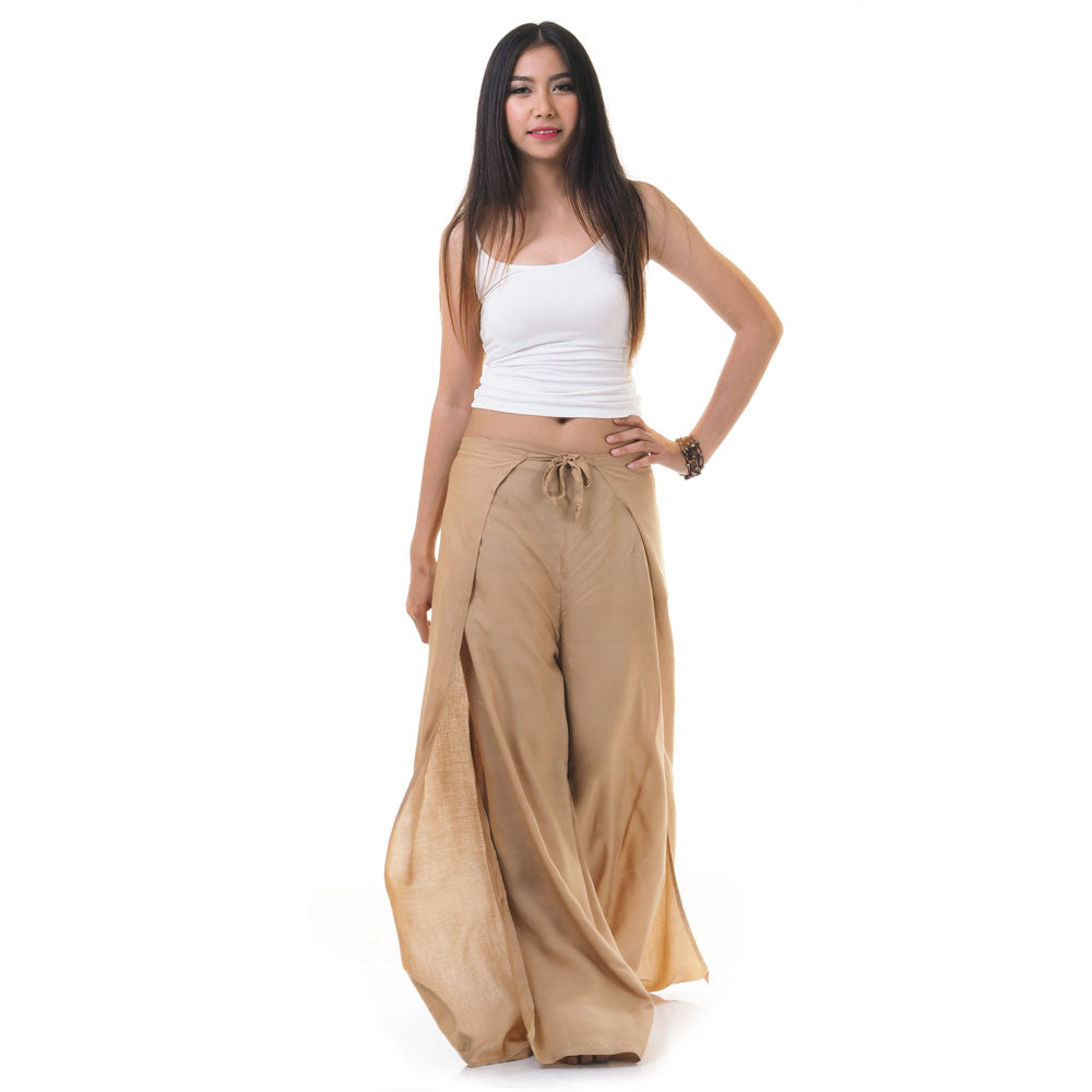 Side view of model in beige Thai wrap pants skirt with white top