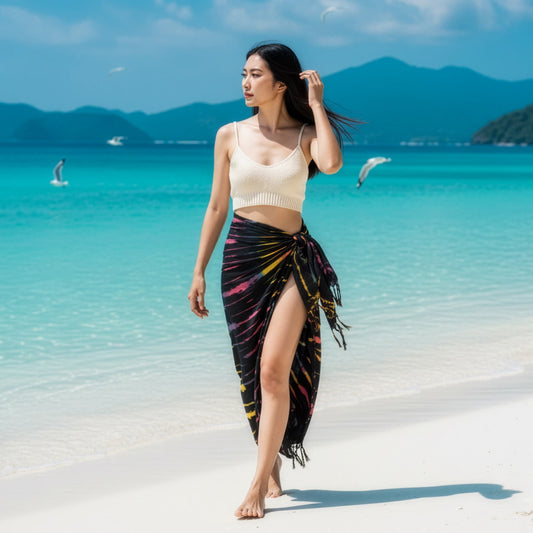 Female model strolling by the ocean in the Midnight Black Sarong Phangan, a versatile alternative to harem pants.
