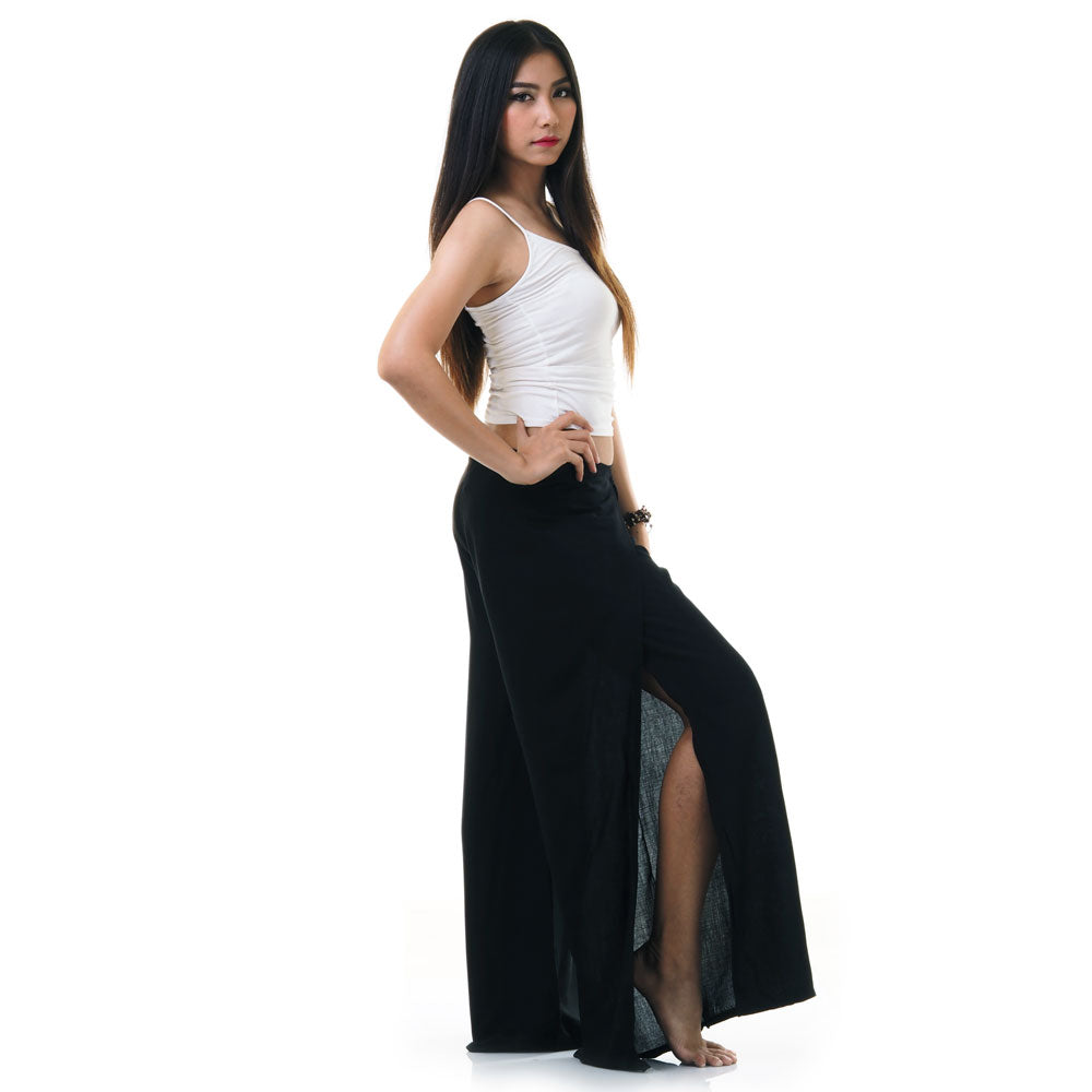 Side view of model in black Thai wrap pants skirt with white top