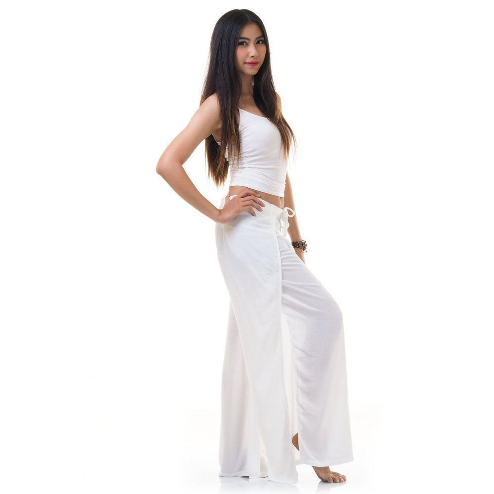 Side view of model in white Thai wrap pants skirt with white top