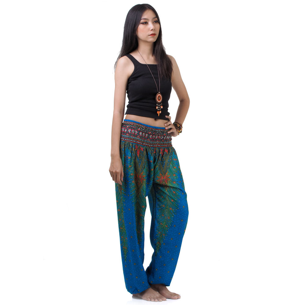 Side view of model in blue Thai harem yoga pants with peacock print and black top