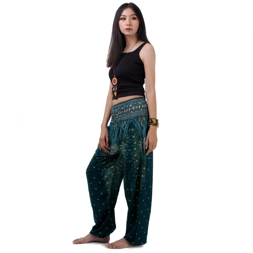Side view of model in turquoise Thai harem yoga pants with peacock print and black top