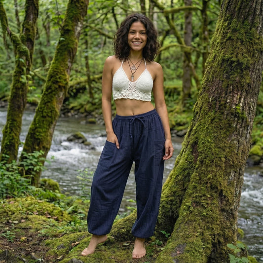 Model in Blue Lagoon pinstripe pants standing by a stream, showcasing a mix of comfort and style.