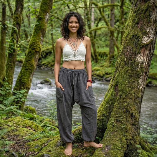 Atmospheric shot of a model in Elephant Gray pinstripe harem pants by a stream in the woods.