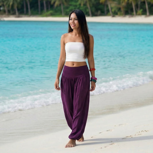 Female model in purple orchid Thai harem pants walking on a Thai beach, demonstrating the sophisticated free size fit.