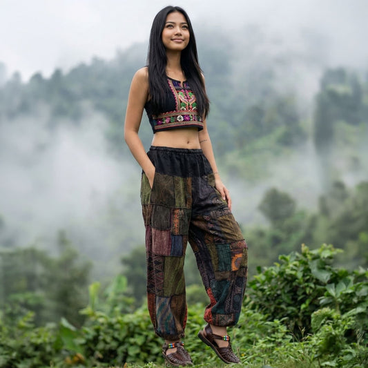 Female model wearing brown Thai harem pants on a path in a misty green landscape front view