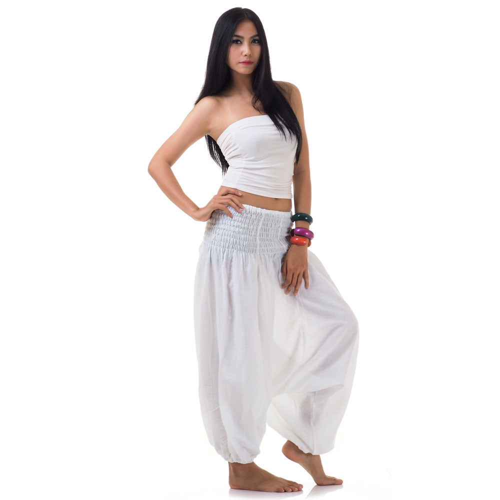 Side view of model in white thai 2-in-1 jumpsuit harem pants with white top