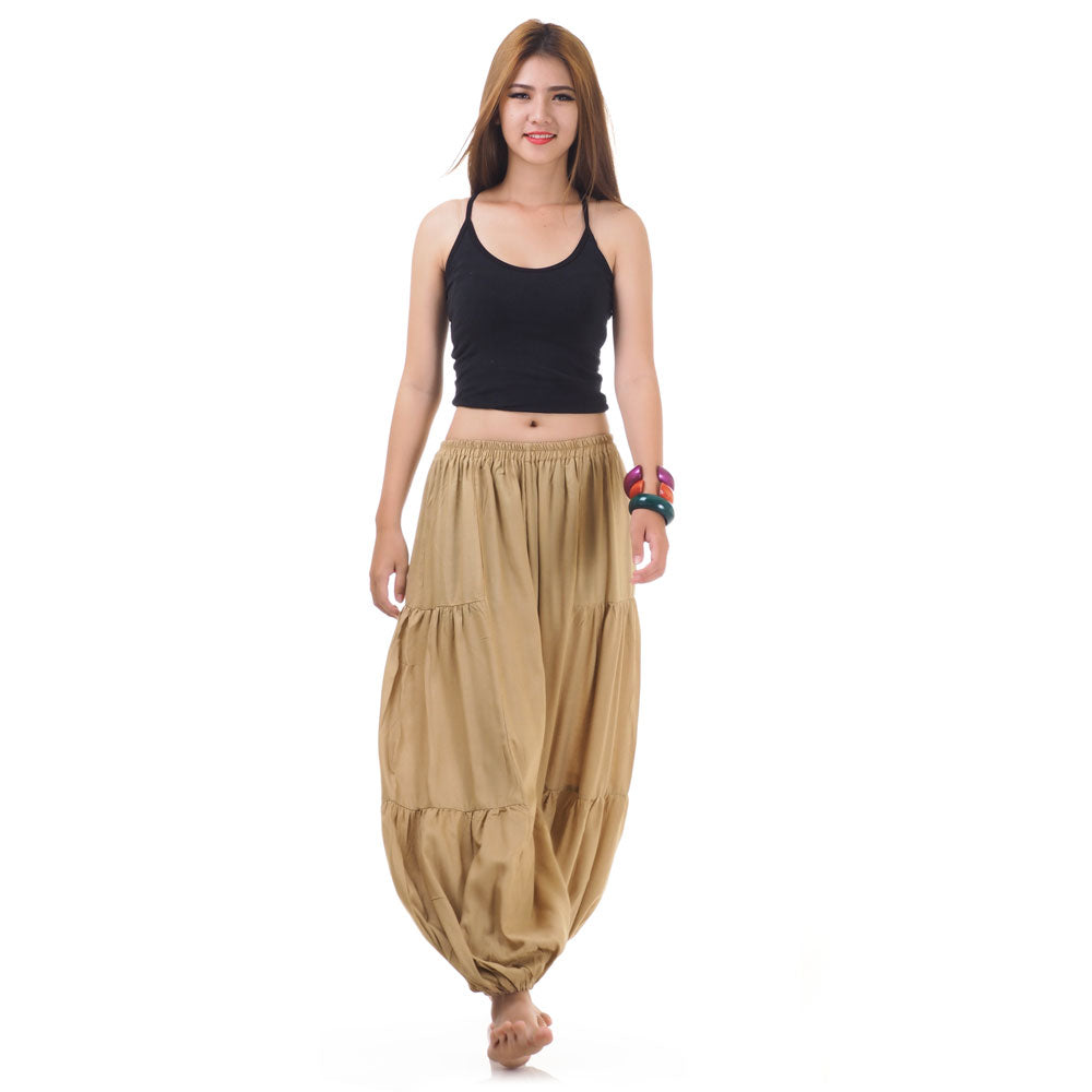 Female model wearing a beige women Thai harem yoga pants with black shirt, front view