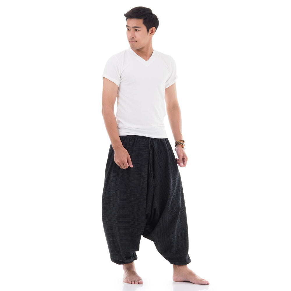 Side view of male model in Black pinstripe drop crotch Thai harem pants with white shirt