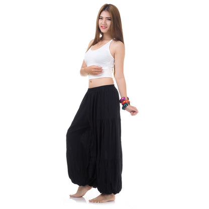 Side view of female model in black women Thai harem yoga pants with white top