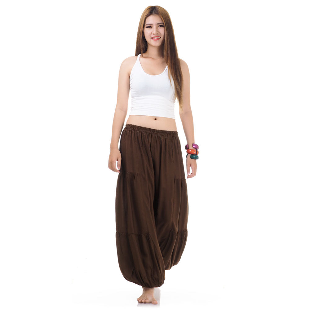 Female model wearing a brown women Thai harem yoga pants with white top, front view