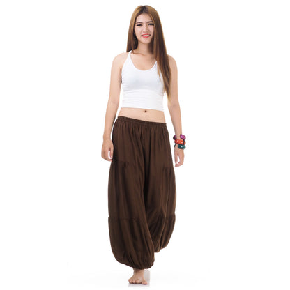 Female model wearing a brown women Thai harem yoga pants with white top, front view