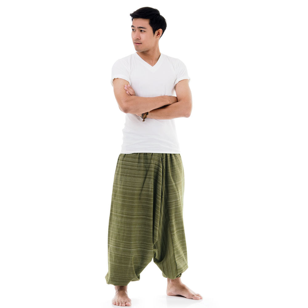 Side view of male model in green pinstripe drop crotch Thai harem pants with white shirt