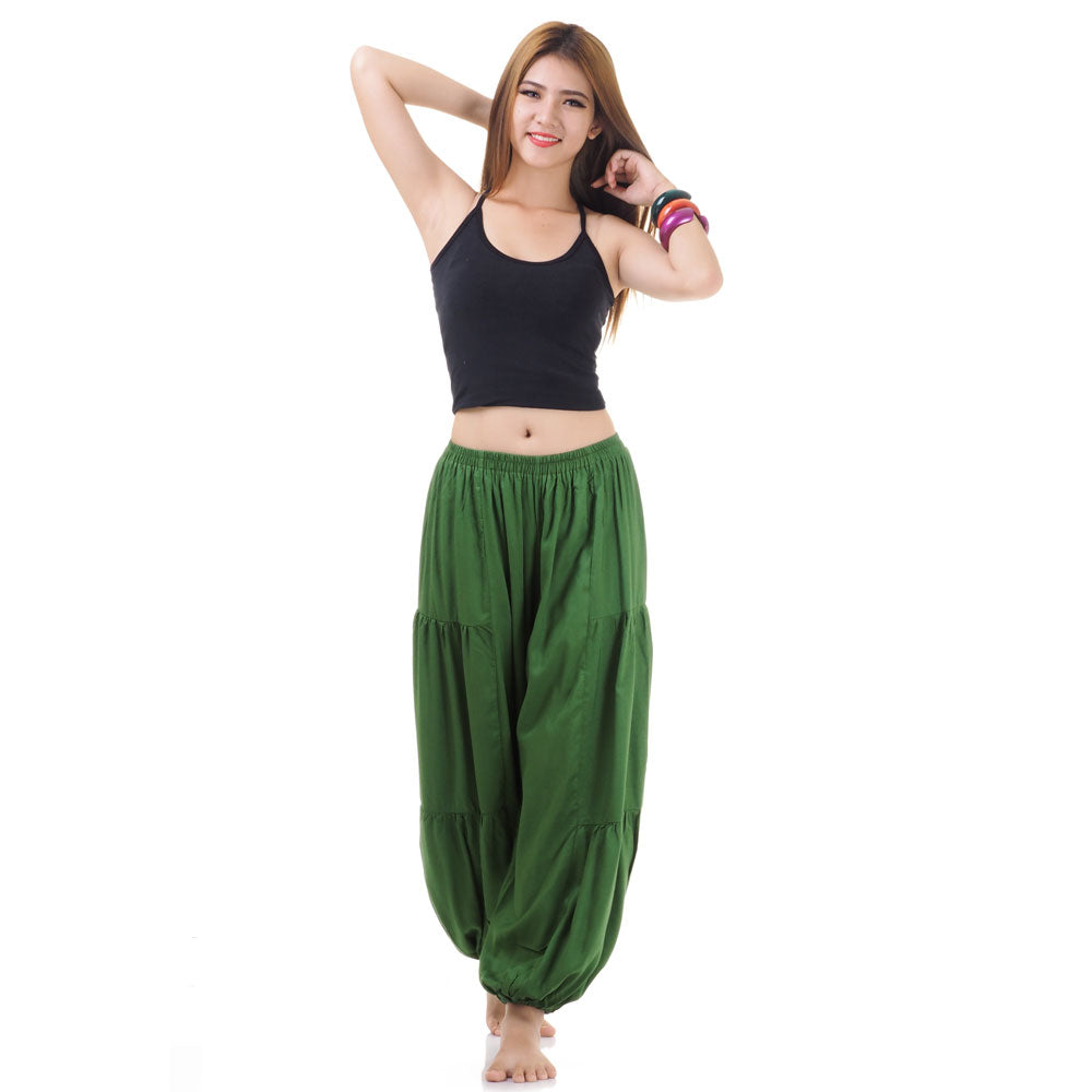 Female model wearing a green women Thai harem yoga pants with black shirt, front view