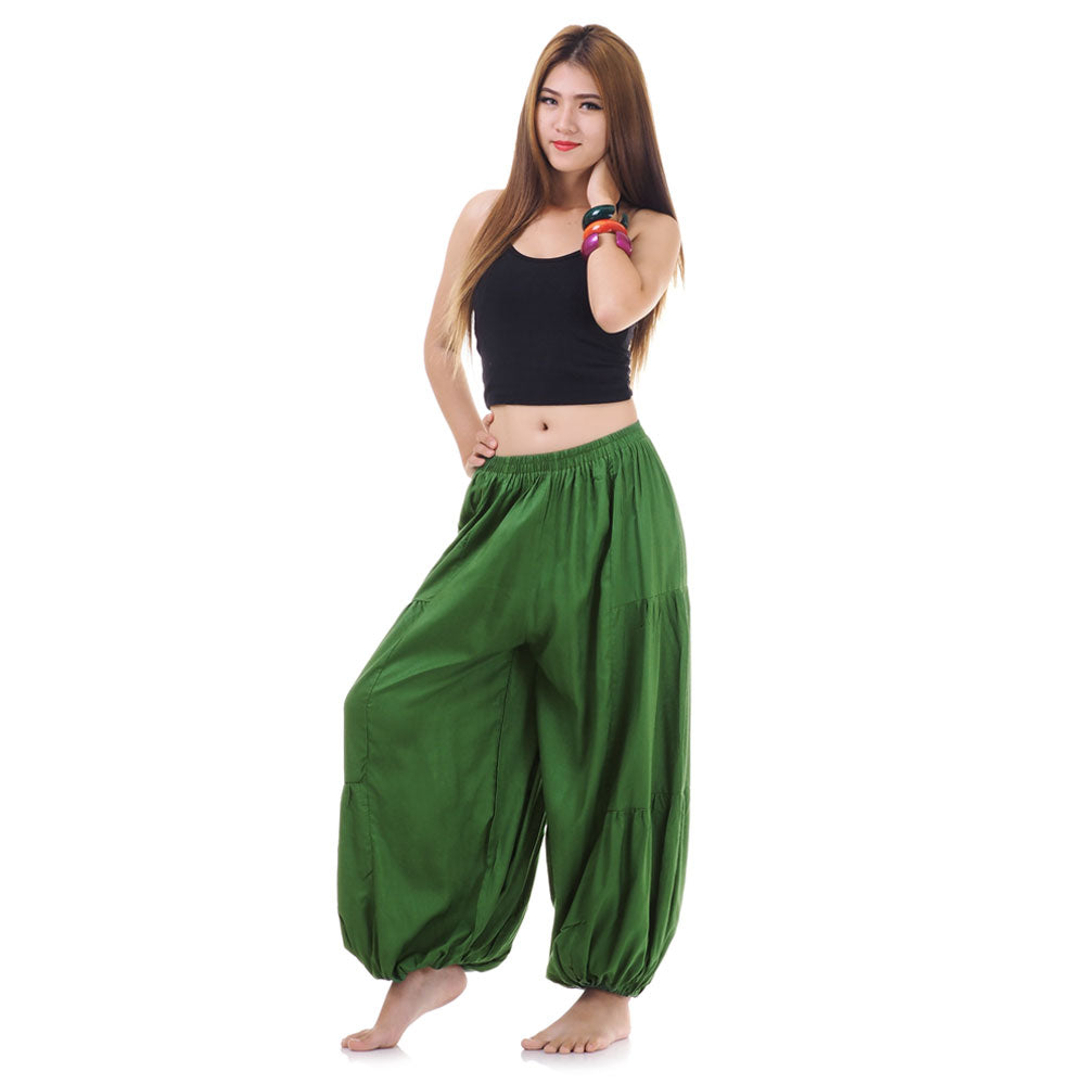 Side view of female model in green women Thai harem yoga pants with black shirt