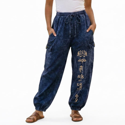 Close-up of blue stonewashed lotus harem pants showing detailed floral prints and cargo pockets.