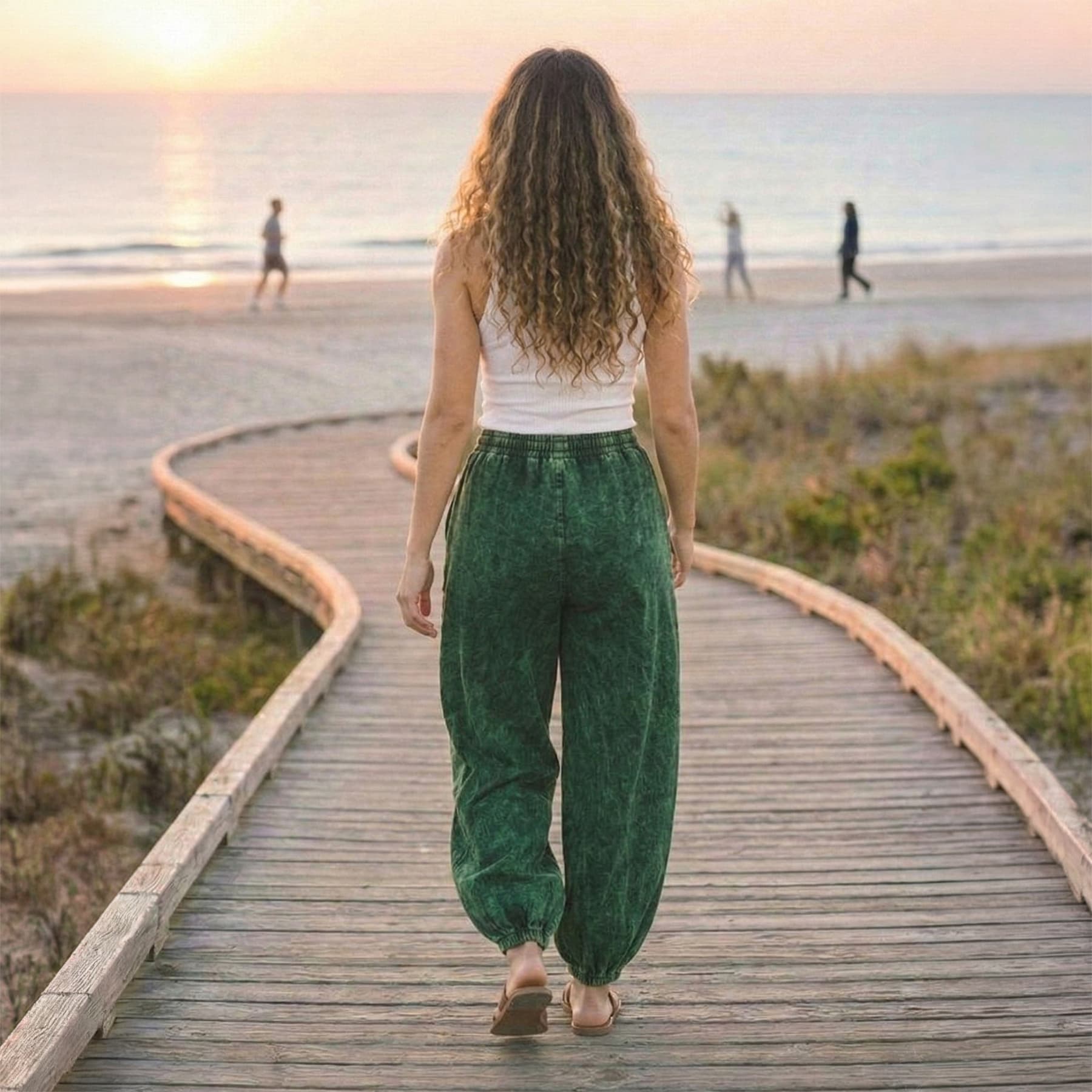 Back view of green boho stonewashed lotus harem pants showing the elastic ankle cuffs and lotus print.