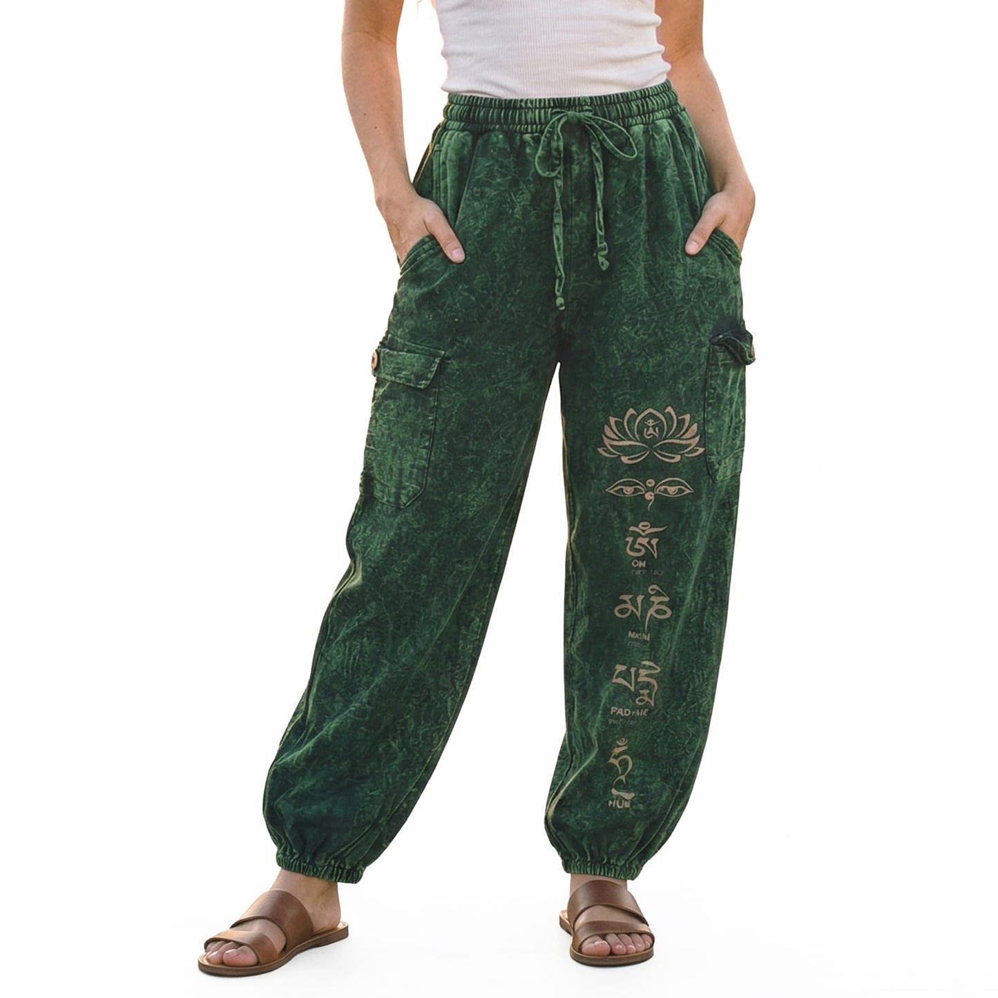 Close-up detail of green stonewashed lotus harem pants with handcrafted floral symbols and cargo pockets.