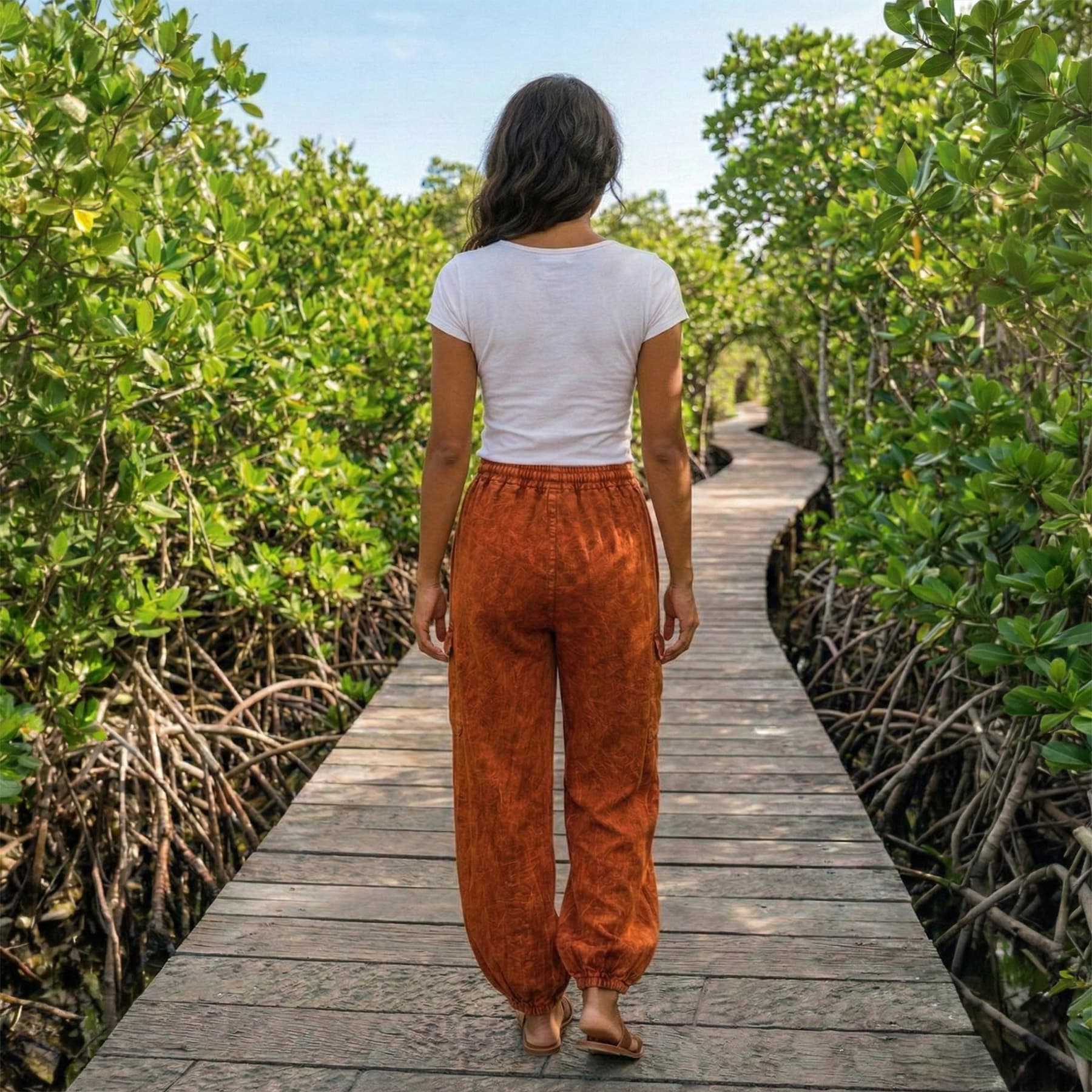 Back view of orange boho stonewashed lotus harem pants showing the flexible fit and ankle cuffs.