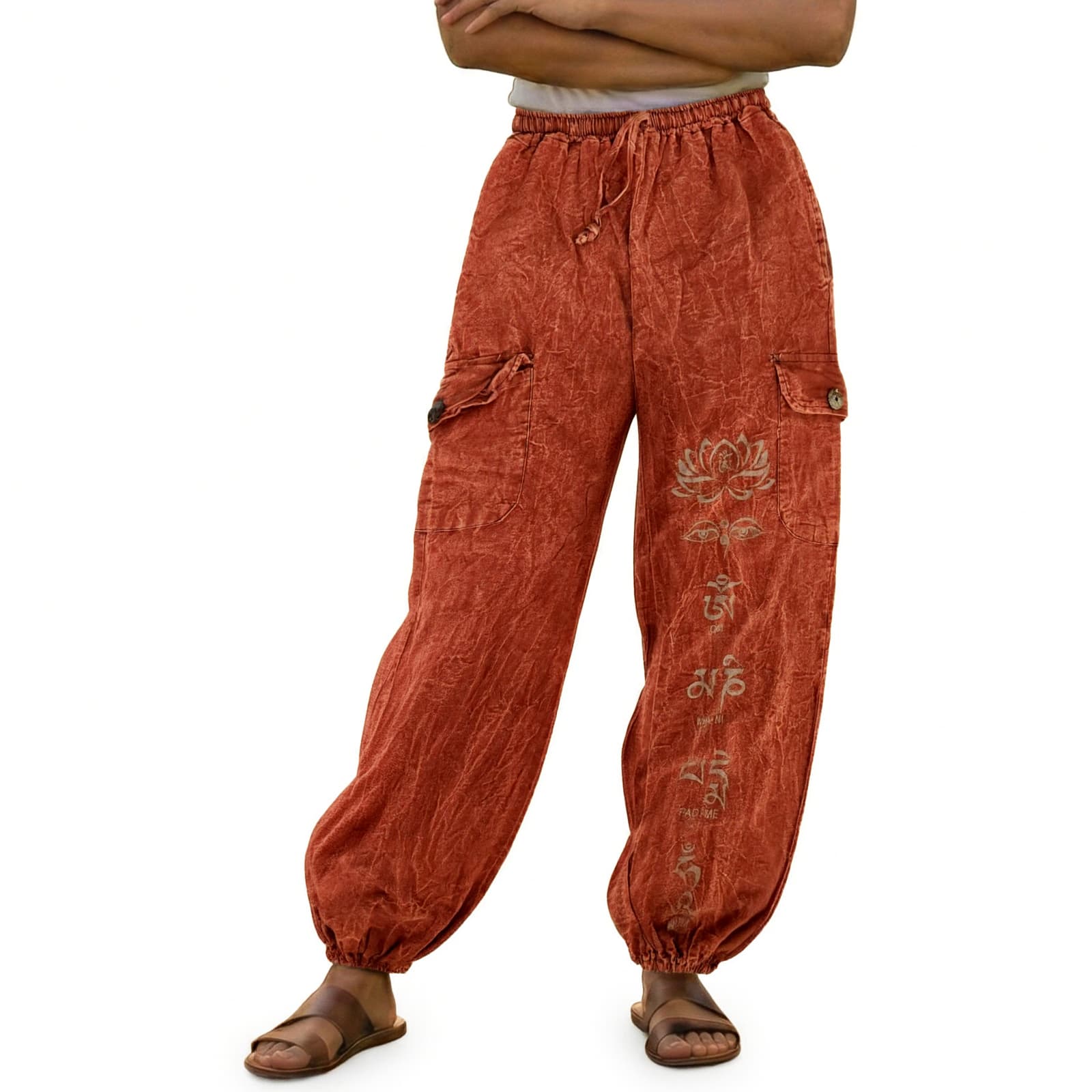 Close-up of orange stonewashed lotus harem pants focusing on the vibrant fabric and floral lotus prints.