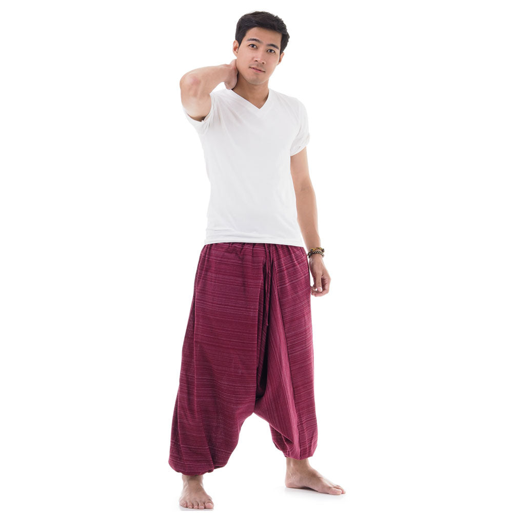 Side view of male model in maroon pinstripe drop crotch Thai harem pants with white shirt