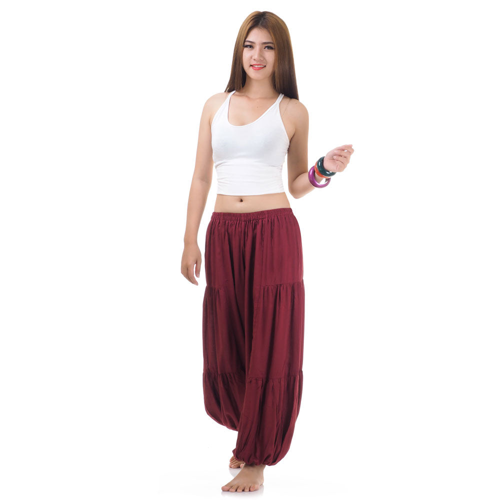 Female model wearing a maroon women Thai harem yoga pants with white top, front view