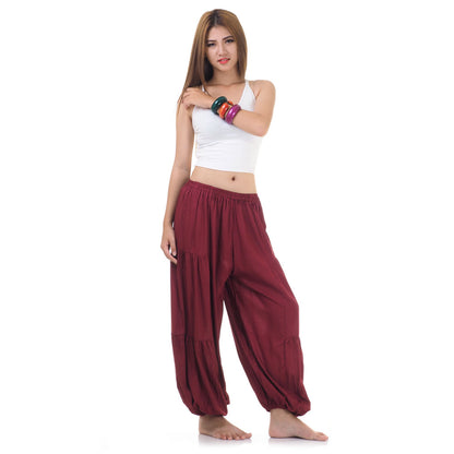 Side view of female model in maroon women Thai harem yoga pants with white top