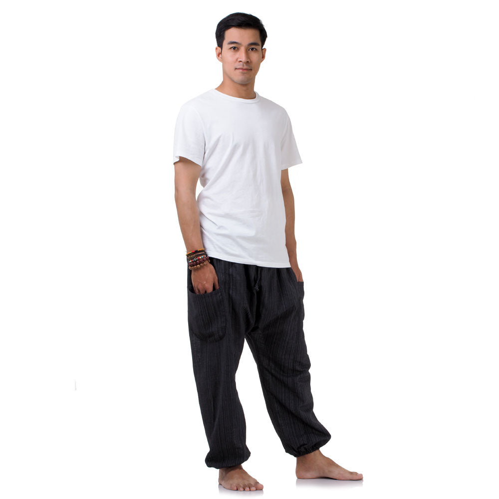 Side view of the black pinstripe pants, showing the flexible elastic waist and ankle cuffs.