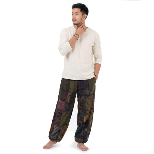 Male model wearing a brown men Thai patchwork harem yoga pants with white shirt, front view