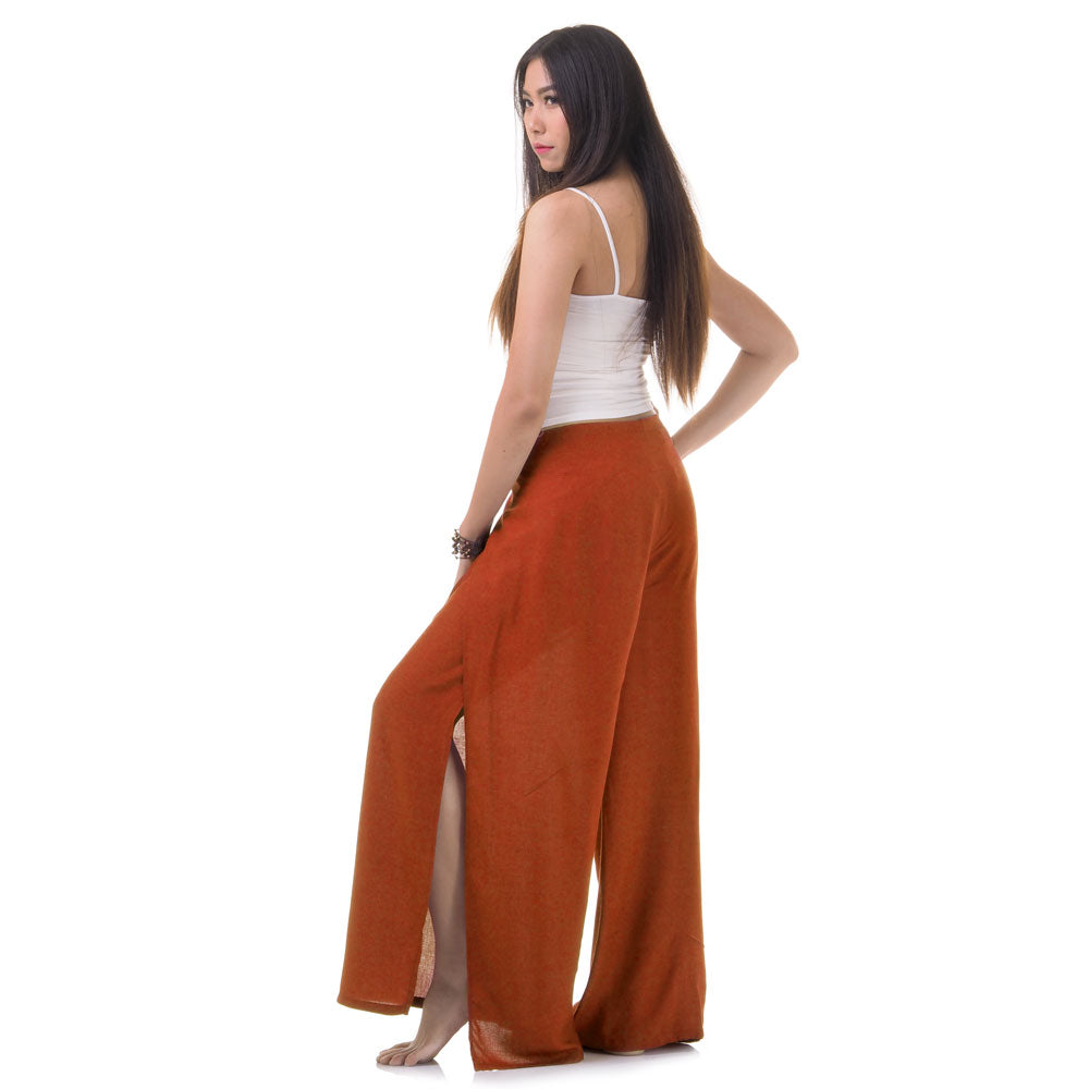 Side view of model in orange Thai wrap pants skirt with white top