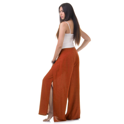 Side view of model in orange Thai wrap pants skirt with white top