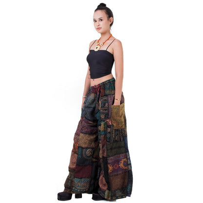 Side view of black wide-leg boho patchwork palazzo pants highlighting the side pocket.