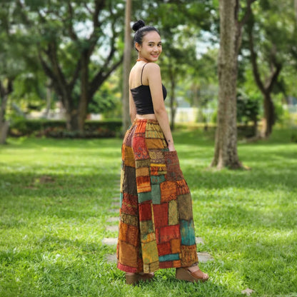 Back view of orange patchwork wide-leg palazzo pants in a park setting.