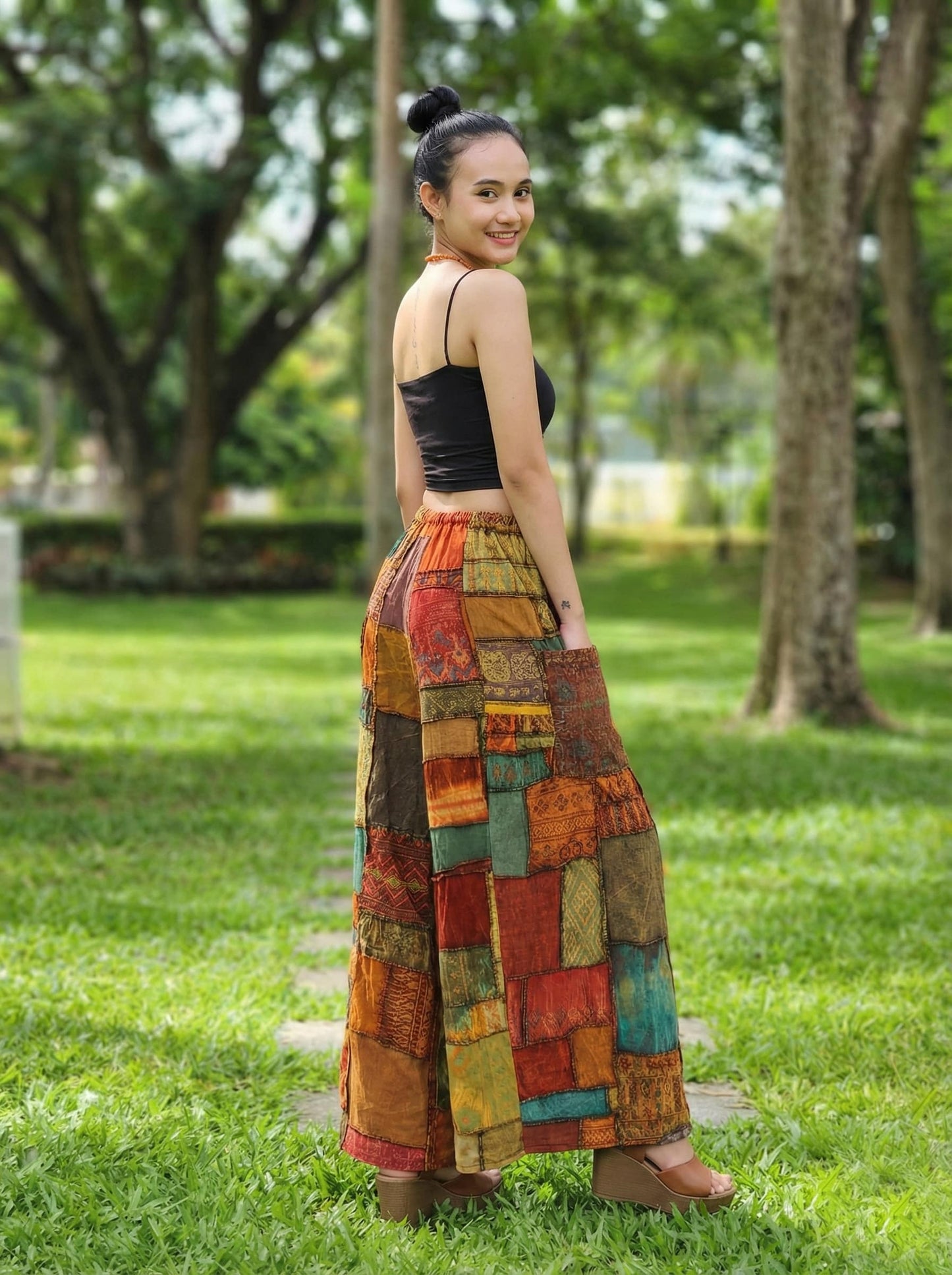 Woman wearing a colorful patchwork hippie palazzo pants in a park