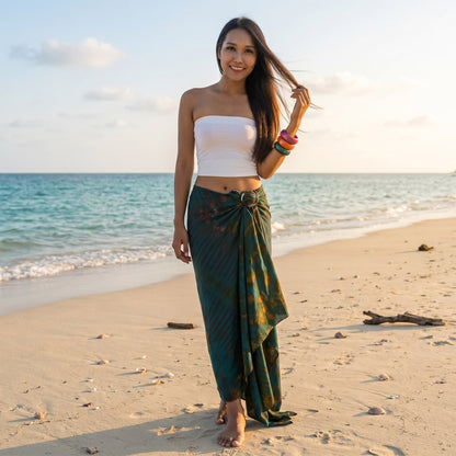 Female model in a tropical setting wearing the Green Vitality Tie Dye wrap skirt Phi Phi by the ocean.