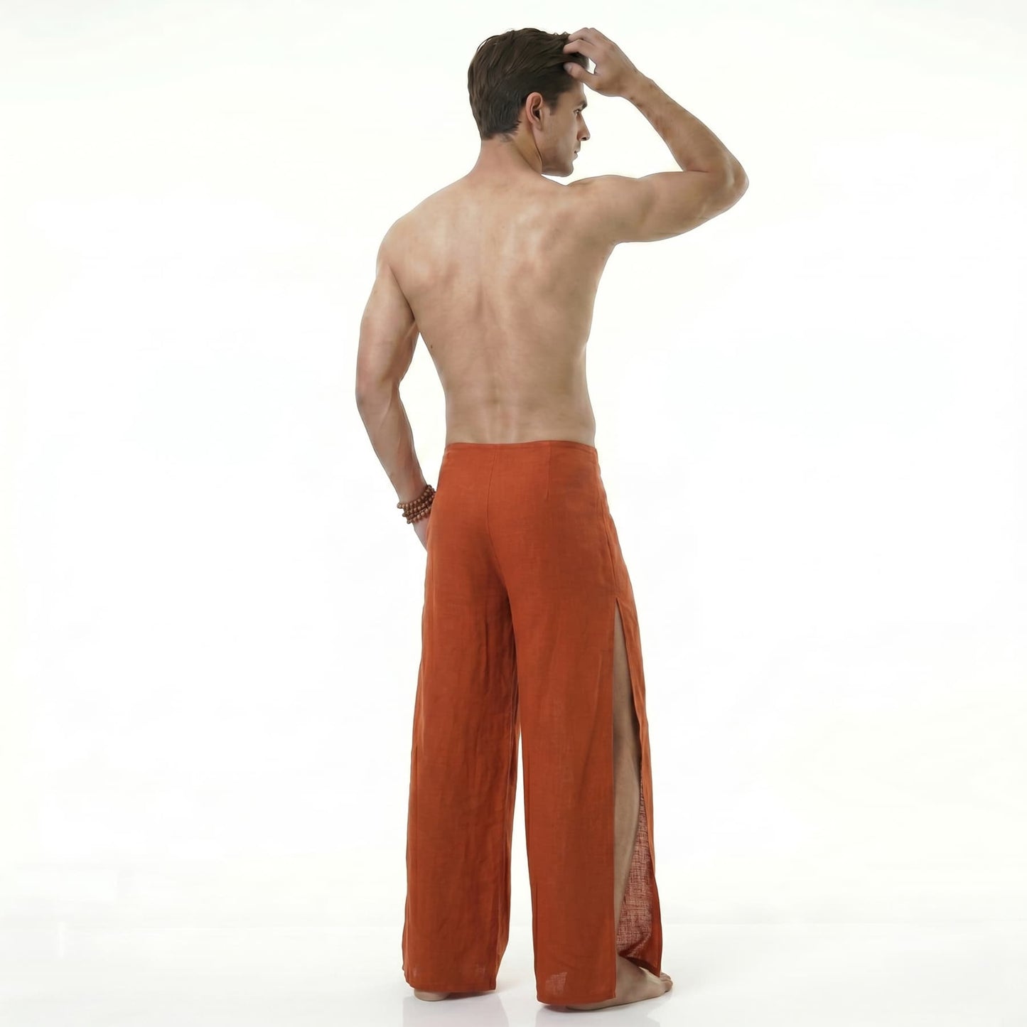 Rear view of the orange Men's Thai wrap pants, emphasizing the lightweight, flowy material.