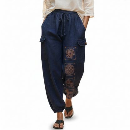 Close-up of blue stonewashed tribal mandala harem pants showing detailed ethnic prints and cargo pockets.