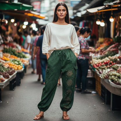 Woman posing in green boho stonewashed mandala pants at a Thai market showing the functional pockets.
