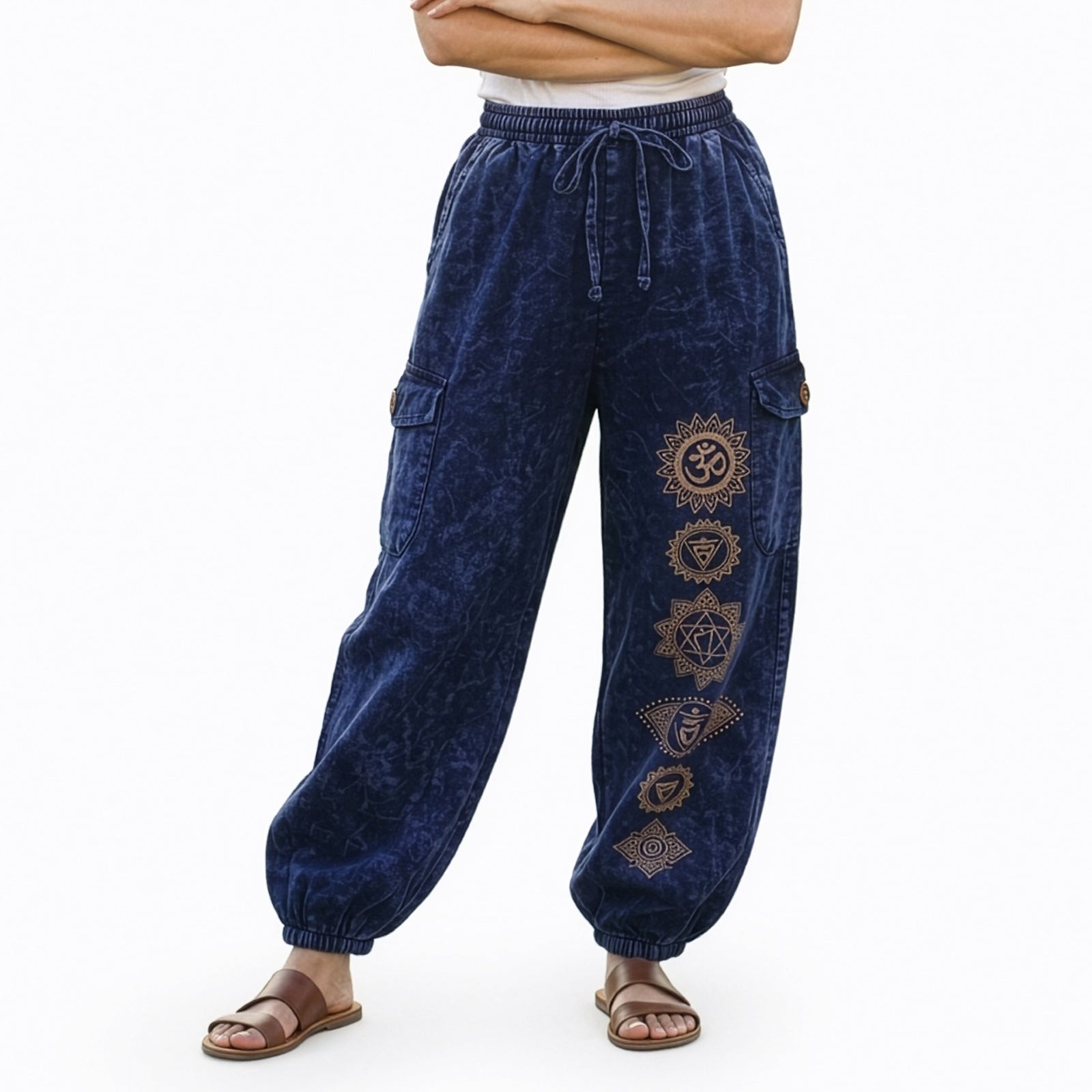 Close-up of blue stonewashed tribal om harem pants showing ethnic prints and cargo pocket detail.
