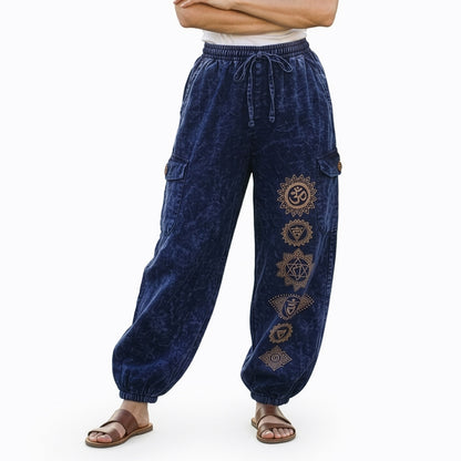 Close-up of blue stonewashed tribal om harem pants showing ethnic prints and cargo pocket detail.
