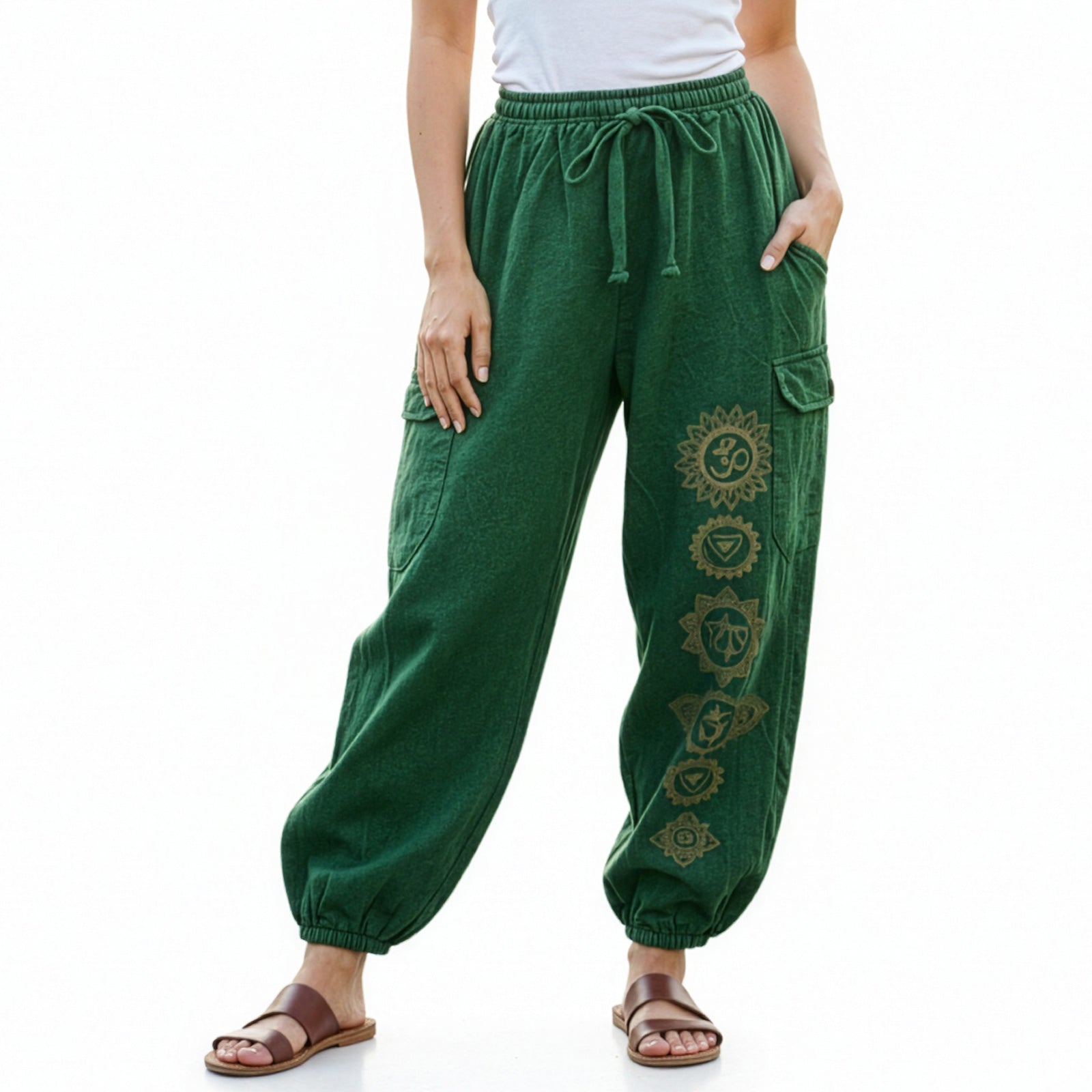 Close-up detail of green stonewashed tribal om harem pants with handcrafted symbols and cargo pockets.