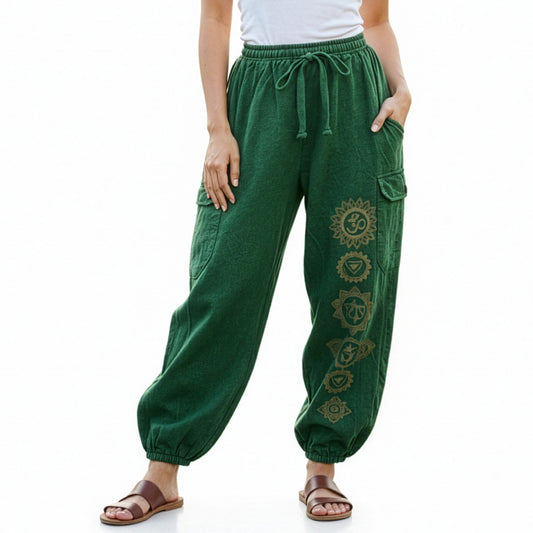 Close-up detail of green stonewashed tribal om harem pants with handcrafted symbols and cargo pockets.