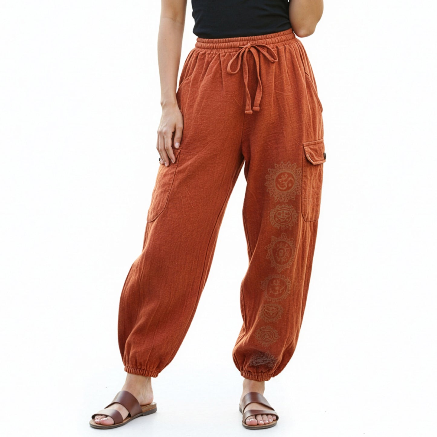 Close-up of orange stonewashed tribal om harem pants focusing on the stonewashed fabric and prints.