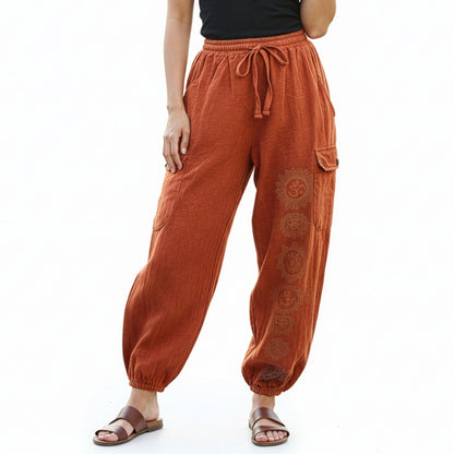 Close-up of orange stonewashed tribal om harem pants focusing on the stonewashed fabric and prints.