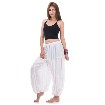 Side view of female model in white women Thai harem yoga pants with black shirt