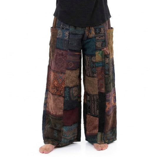 Close-up of black patchwork men’s boho pants showing detailed ethnic patterns and cotton fabric.