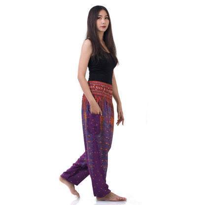 Side view of model in purple Thai harem yoga pants with peacock print and black top