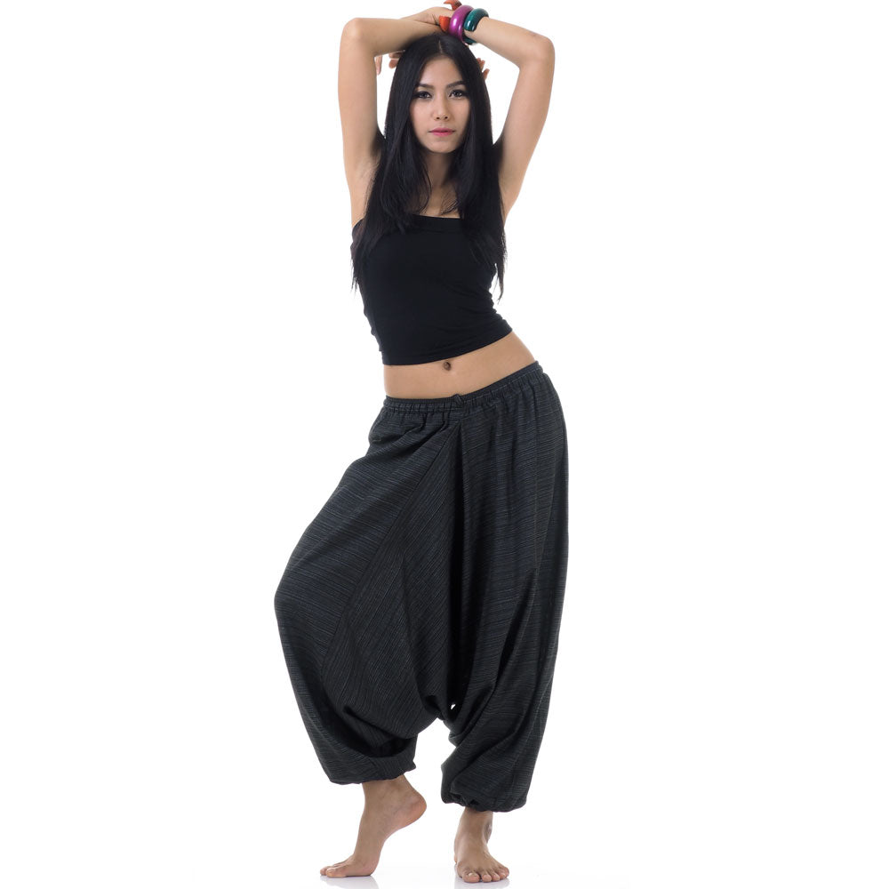 Model wearing black women pinstripe drop crotch thai harem pants with black top, front view
