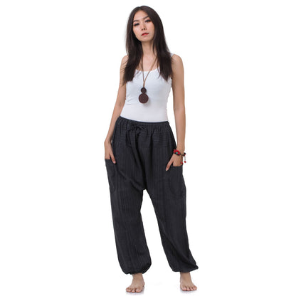 Front view of the Black Sand Women's Pinstripe Harem Pants with functional side pockets.