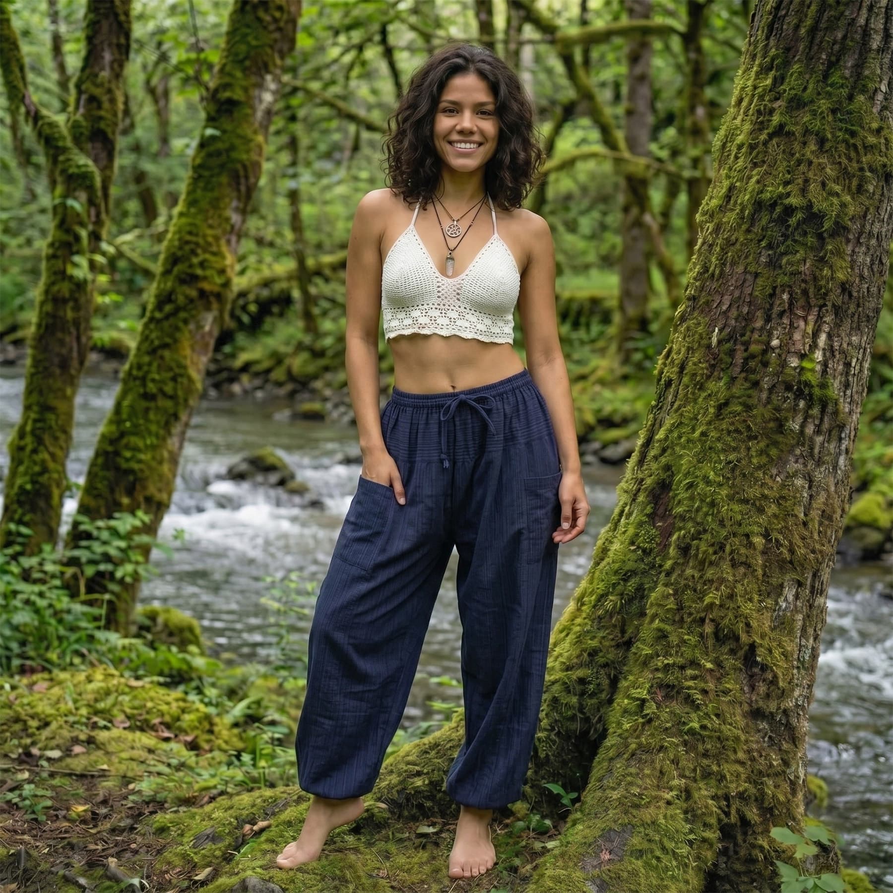 Model in Blue Lagoon pinstripe pants standing by a stream, showcasing a mix of comfort and style.